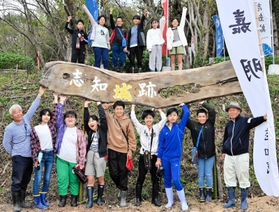 看板を作った志知城守る会の関口功代表（前列左）、福岡造園緑化の福岡清会長（同右）と、色塗りで手伝った志知小学校６年生＝志知城跡