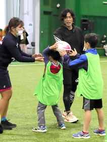 ラグビーボールの持ち方をアドバイスする大畑大介さん＝県立淡路佐野運動公園