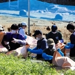 胴長姿で水草を回収する参加者＝本田池