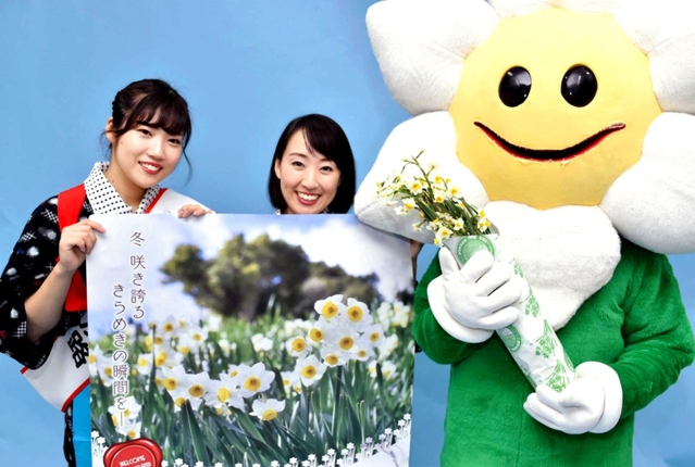 南あわじ市灘黒岩の灘黒岩水仙郷で咲き誇るニホンスイセンのＰＲで訪れたご当地キャラクター「すいせんなんちゃん」と第３８代クイーン淡路の２人＝神戸市中央区東川崎町１、神戸新聞本社
