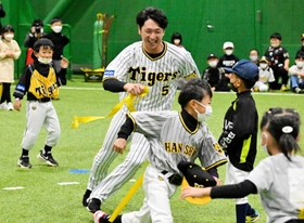 腰の帯を狙い子どもたちを追いかける近本光司選手＝淡路佐野運動公園