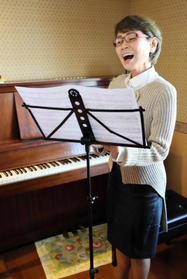 音楽教室のレッスン室で歌う安永郁子さん＝洲本市