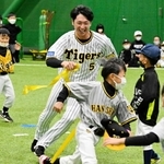 腰の帯を狙い子どもたちを追いかける近本光司選手＝淡路佐野運動公園