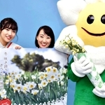 南あわじ市灘黒岩の灘黒岩水仙郷で咲き誇るニホンスイセンのＰＲで訪れたご当地キャラクター「すいせんなんちゃん」と第３８代クイーン淡路の２人＝神戸市中央区東川崎町１、神戸新聞本社