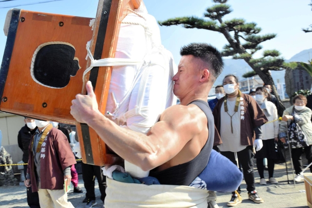 怪力自慢の男衆が歯を食いしばり餅を運んだ＝南あわじ市北阿万筒井