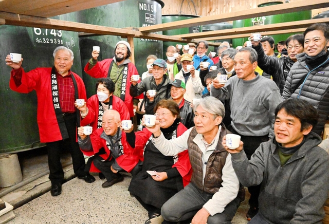 ２８年前に思いをはせ献杯する淡路酒探偵団のメンバーら＝千年一酒造