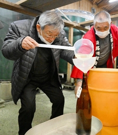 搾りたての酒を瓶詰めする参加者＝千年一酒造
