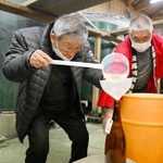 搾りたての酒を瓶詰めする参加者＝千年一酒造