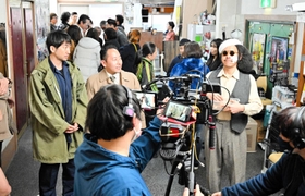 館内ロビーで撮影する出演者とエキストラ＝洲本オリオン