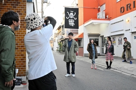 ポスター撮影に臨む波岡一喜さん（中央）ら出演者＝洲本オリオン