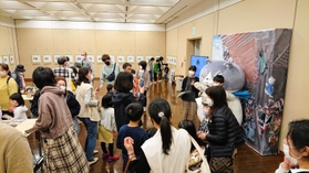 マルと記念撮影する家族連れで混み合う会場＝洲本市文化体育館