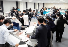 会議室での開票作業。奥に固定されたビデオカメラが様子を撮影した＝淡路市役所２号館