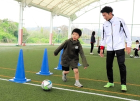 指導役の選手からボールさばきを教わる参加者＝淡路市生穂新島