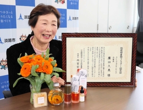 カレンデュラの花と加工した商品を前にマイスター認定を喜ぶ廣田久美さん＝淡路市役所