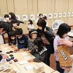 マルのスタンプやおみくじを楽しむ親子連れ＝洲本市文化体育館