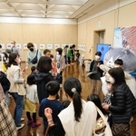 マルと記念撮影する家族連れで混み合う会場＝洲本市文化体育館