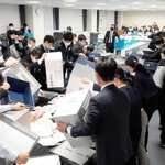 会議室での開票作業。奥に固定されたビデオカメラが様子を撮影した＝淡路市役所２号館