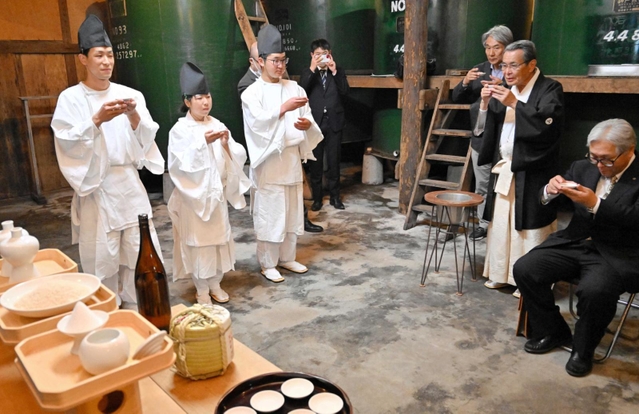 本名孝至宮司の音頭で乾杯する（左から）島本巧さん、因來理紗さん、木上晴登さん＝千年一酒造