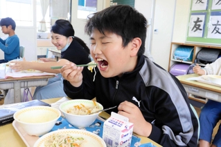 豚丼のタマネギを口に運ぶ児童＝北淡小学校
