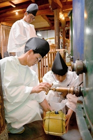 完成した酒のタンクを開ける島本巧さん（手前左）と因來理紗さん（同右）、木上晴登さん（後方）＝千年一酒造
