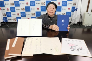 出版した「龍の玉」を持つ奥村幸子さん＝淡路市役所