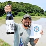 完成した「総邌利（そうねり）」と「インターナショナル・ワイン・チャレンジ」の賞状を手にする塩田宏紀さん＝洲本市五色町