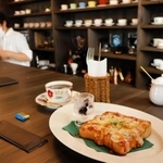 ＧＯＯＤ　ＴＩＭＥブレンドとピザトースト。福榮さん（奥）がコーヒーを準備中＝南あわじ市神代社家