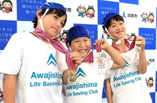 ライフセービングの全国大会で獲得したメダルを手にする宇城湊人君（左）、碧人君（中央）、居守徹大君＝淡路市生穂新島