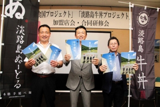 パンフレットを手にＰＲする御食国プロジェクト実行委員会の島野和大委員長（中央）ら＝洲本市文化体育館