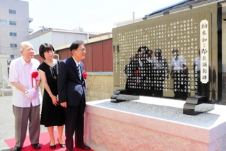 元津名町長、柏木和三郎さんをたたえる顕彰碑を眺める門康彦淡路市長（右）、平田麻希さん（中央）、三原芳明さん＝淡路市志筑