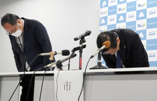 会見で頭を下げる上崎勝規市長（右）と浜辺学副市長＝洲本市役所