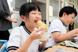 ハモの天ぷらを笑顔で頰張る児童＝榎列小学校