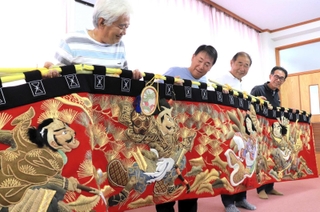修繕した水引幕を持つ斗ノ内浜町内会のメンバー＝淡路市斗ノ内