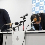 会見で頭を下げる上崎勝規市長（右）と浜辺学副市長＝洲本市役所