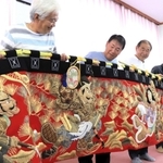 修繕した水引幕を持つ斗ノ内浜町内会のメンバー＝淡路市斗ノ内