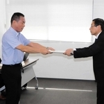 最終報告書を手渡す関西学院大学の上村敏之教授（左）と上崎勝規市長＝９月、洲本市役所