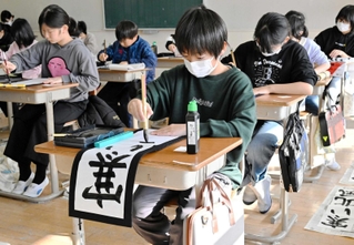 真剣な表情で筆を運ぶ児童たち＝蒼開中学校
