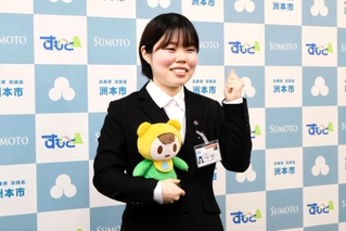 洲本市のキャラクターを手にタンザニア赴任に向け意気込む下山まりさん＝洲本市役所