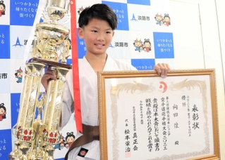 優勝トロフィーと表彰状を持つ向田煌君＝淡路市役所
