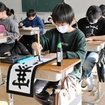 真剣な表情で筆を運ぶ児童たち＝蒼開中学校