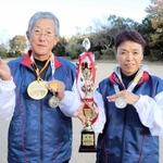全国大会の優勝トロフィーとメダルを掲げる西谷信昭さん（左）と洋子さん＝淡路市生穂新島