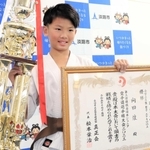 優勝トロフィーと表彰状を持つ向田煌君＝淡路市役所