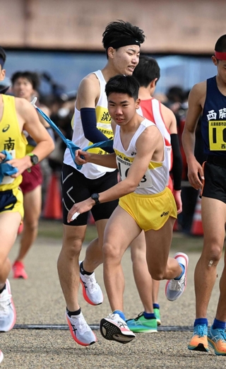 男子・淡路市の２区児島翔太選手（中央奥）からたすきを受ける３区高田有希也選手＝加古川市の加古川河川敷マラソンコース（撮影・風斗雅博）
