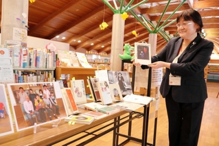 八代さんにまつわる本を手にする木田留美館長＝洲本市五色町鮎原南谷