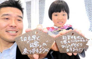 被災地への応援メッセージを書いた絵馬を持つ参加者＝淡路市野島平林