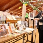 八代さんにまつわる本を手にする木田留美館長＝洲本市五色町鮎原南谷