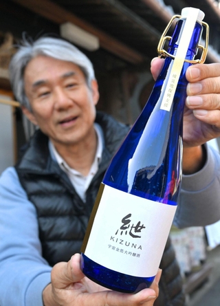 完成した大吟醸酒「紲」を手にする上野山善彦社長＝千年一酒造