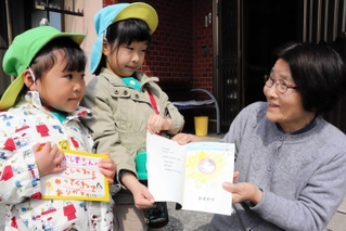 近隣住民へ手作り絵本を渡す多賀保育所の園児＝淡路市下河合