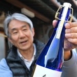 完成した大吟醸酒「紲」を手にする上野山善彦社長＝千年一酒造