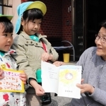 近隣住民へ手作り絵本を渡す多賀保育所の園児＝淡路市下河合